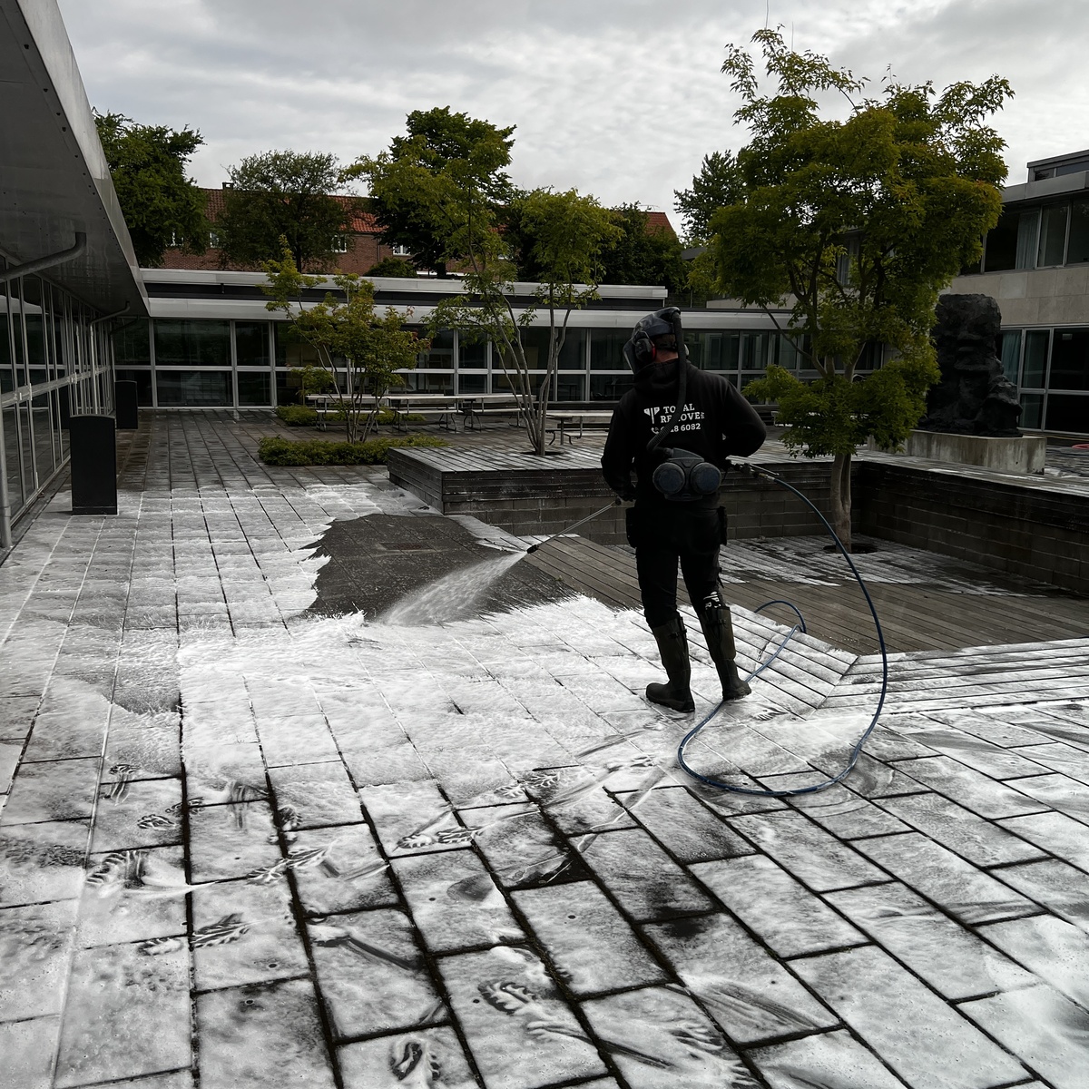 Terrasse med fliser under algebehandling mod sort lav – Total Remove