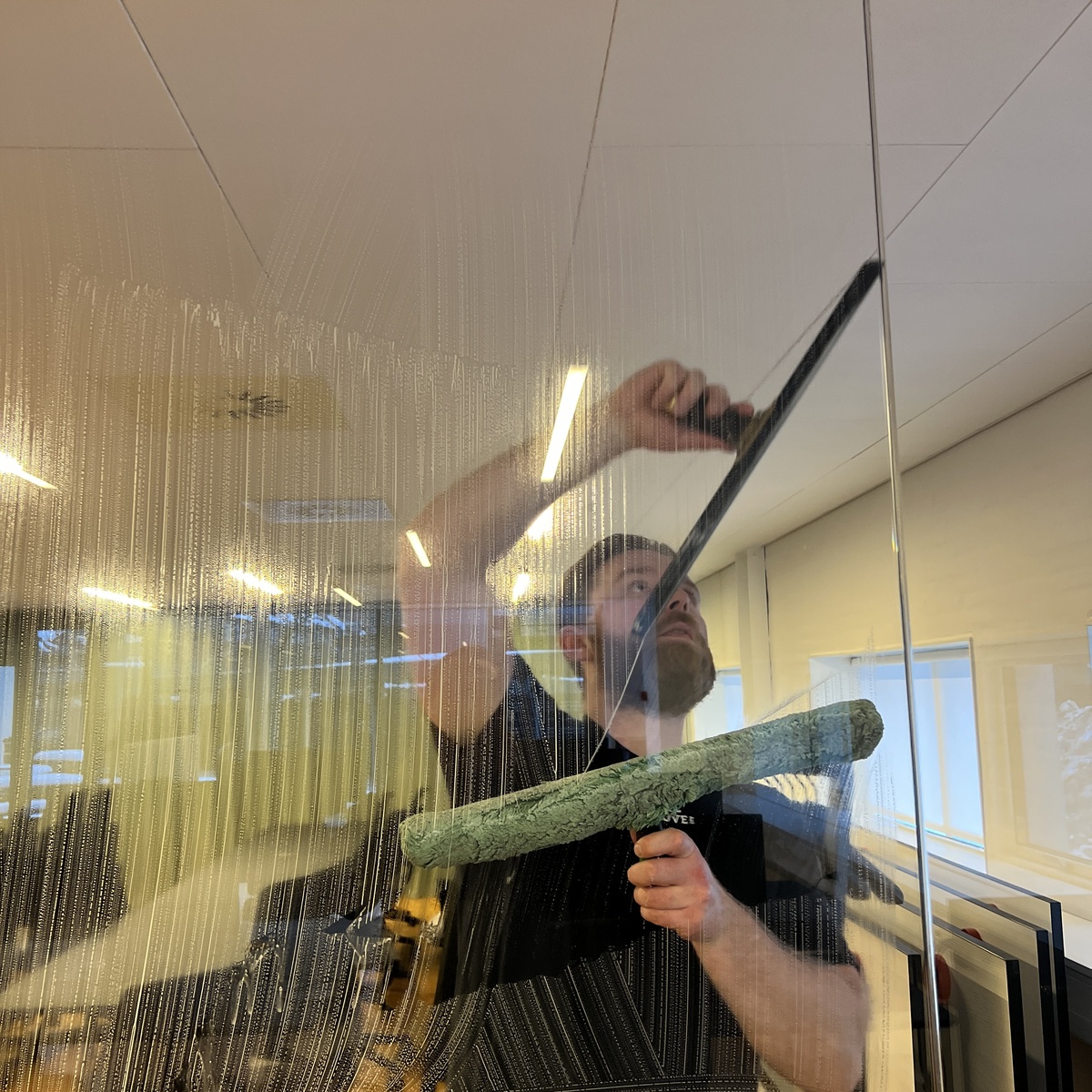 Vinduespudser renser glasrude med skraber